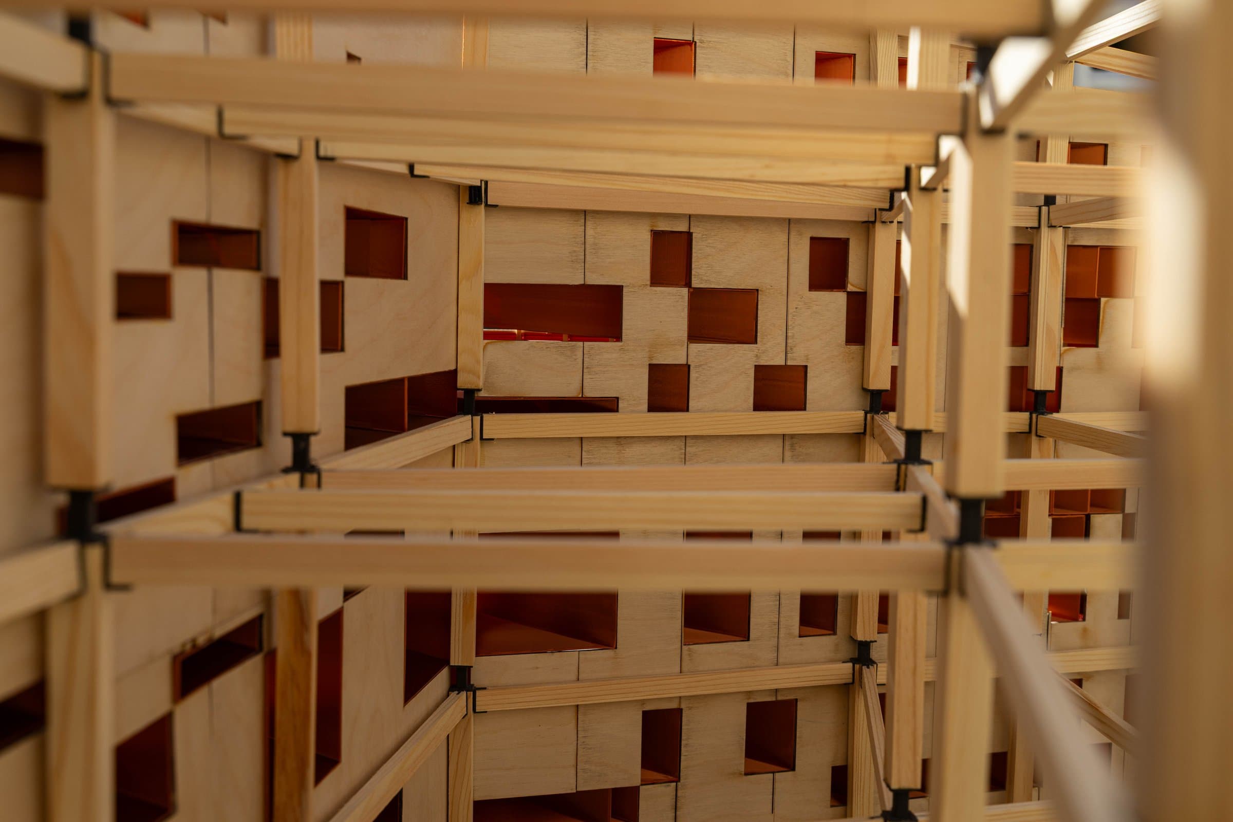 Inside the stick frame, copper panels glimpsed through the openings.