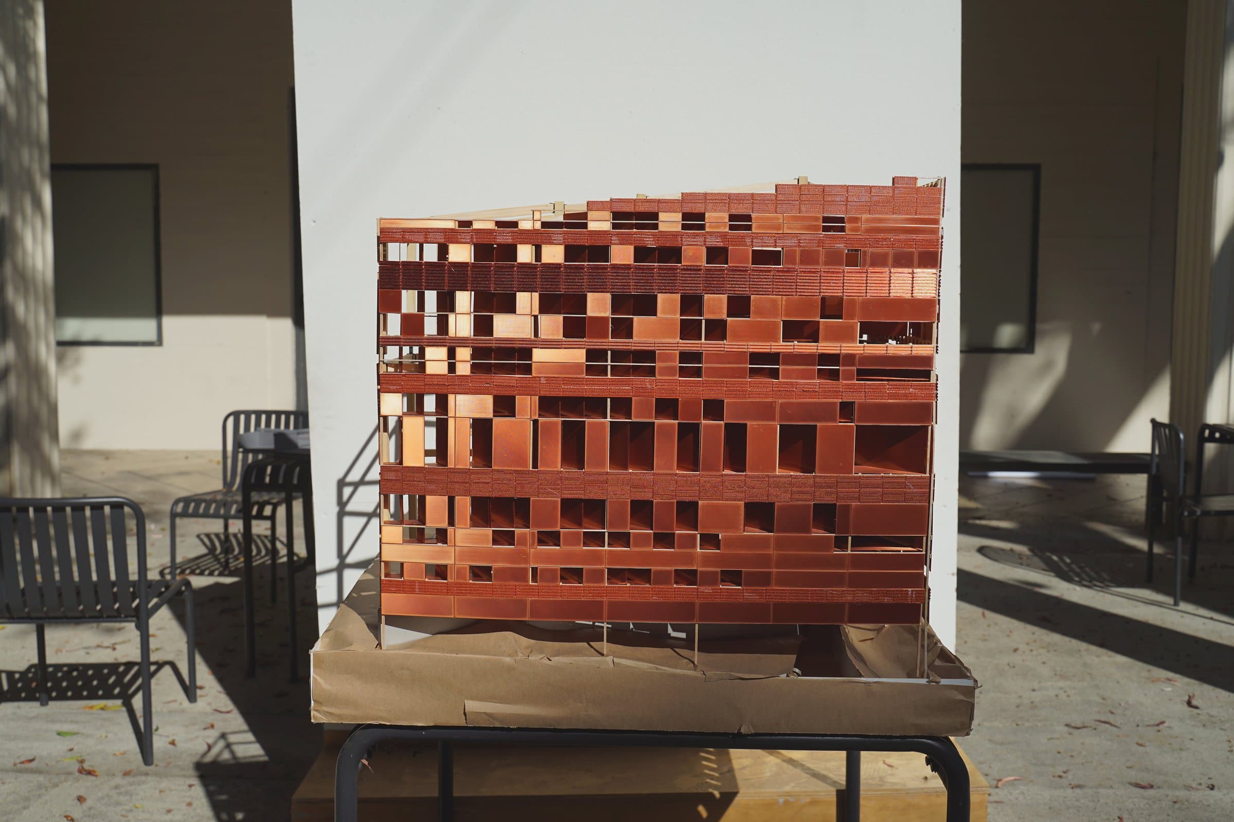 Closer: the copper facade fills the frame above the table.